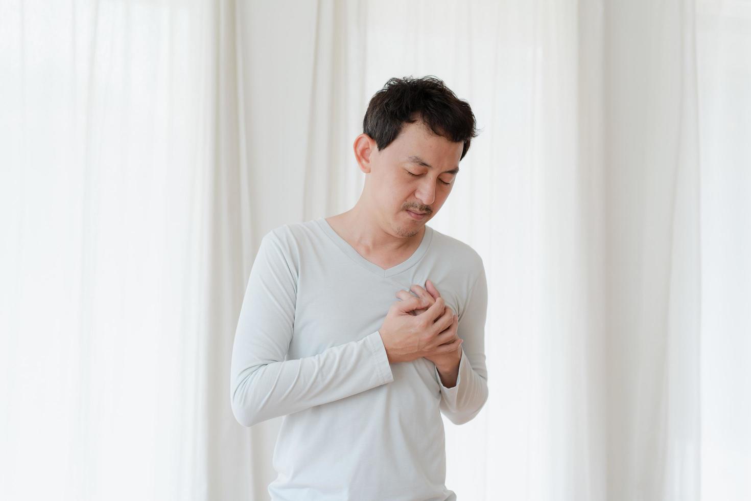 a man touching his heart, with red highlight of heart attack, and others heart disease concept, Heart attack symptom photo