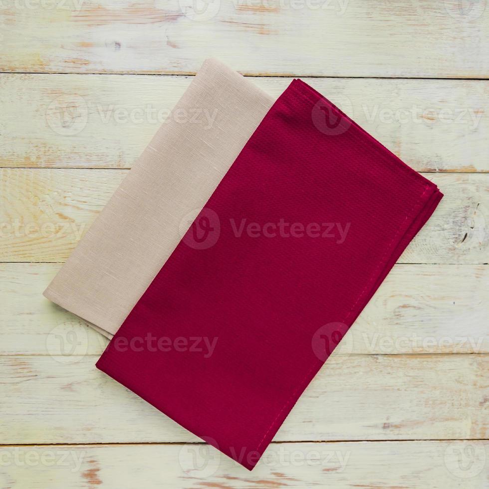 Top view of cloth napkins of beige and burgundy colors in rustic white background. photo