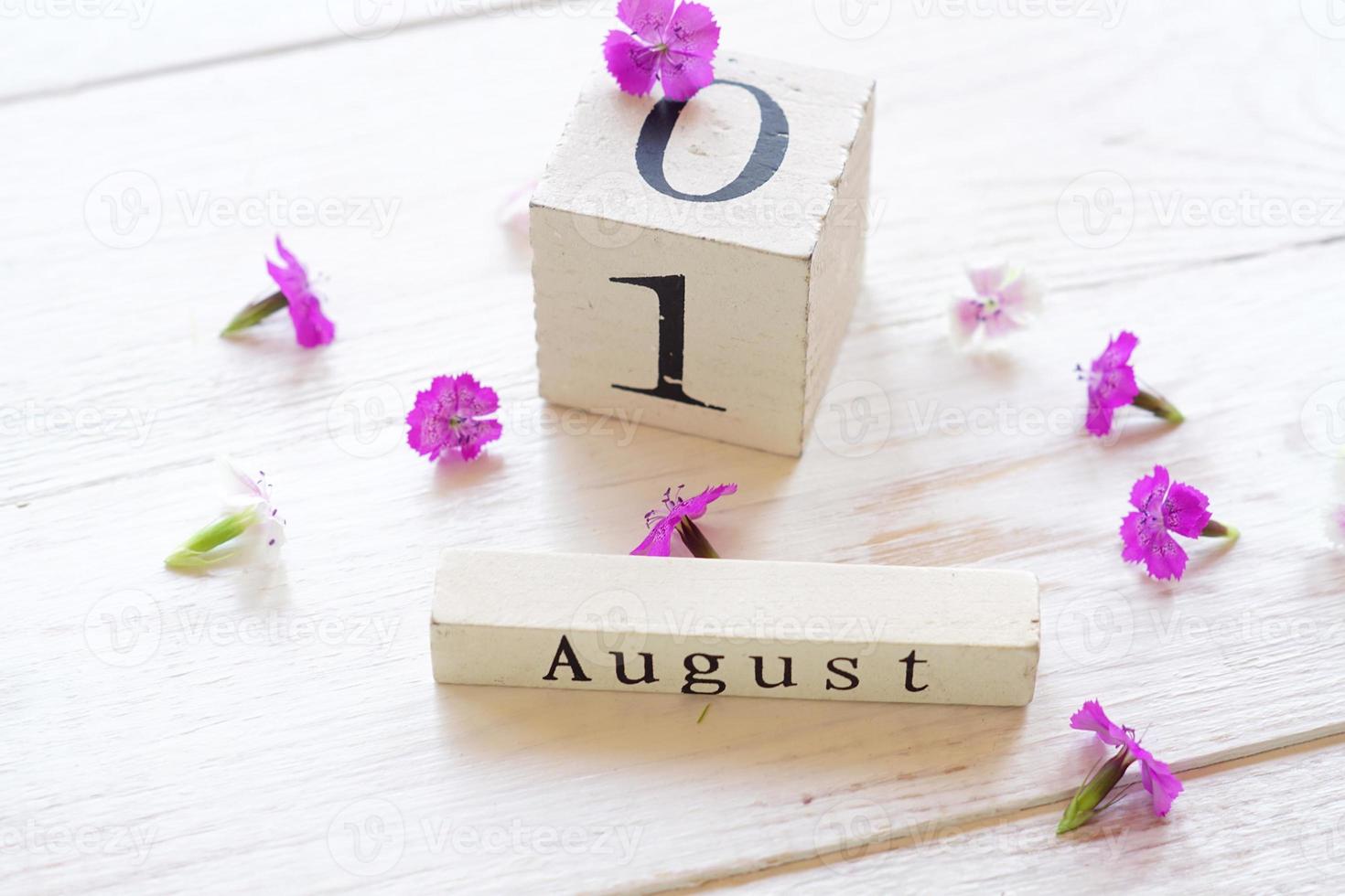 1 August, colorful background with cube wooden calendar and pink flowers photo