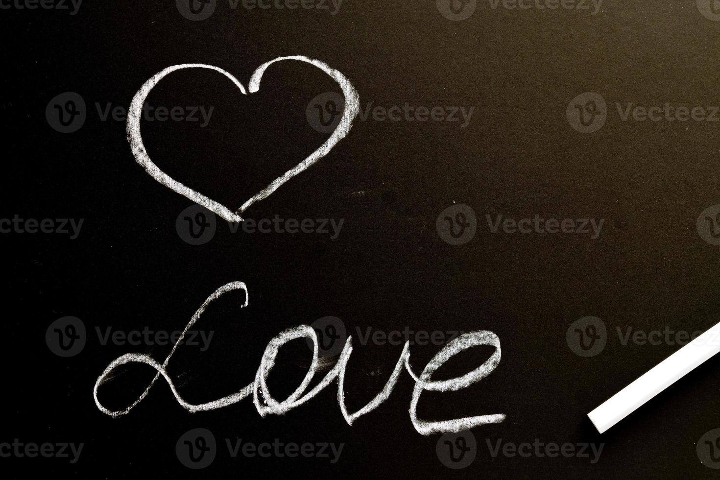 A chalk board with the word love and a heart. Grunge background texture photo