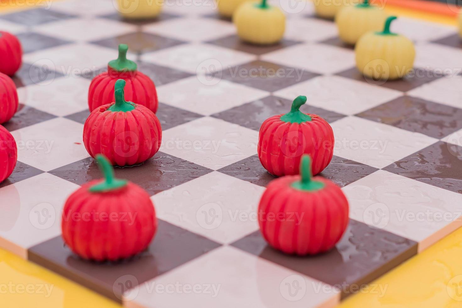 close up of checkered board with pumpkin checkers, colorful background photo