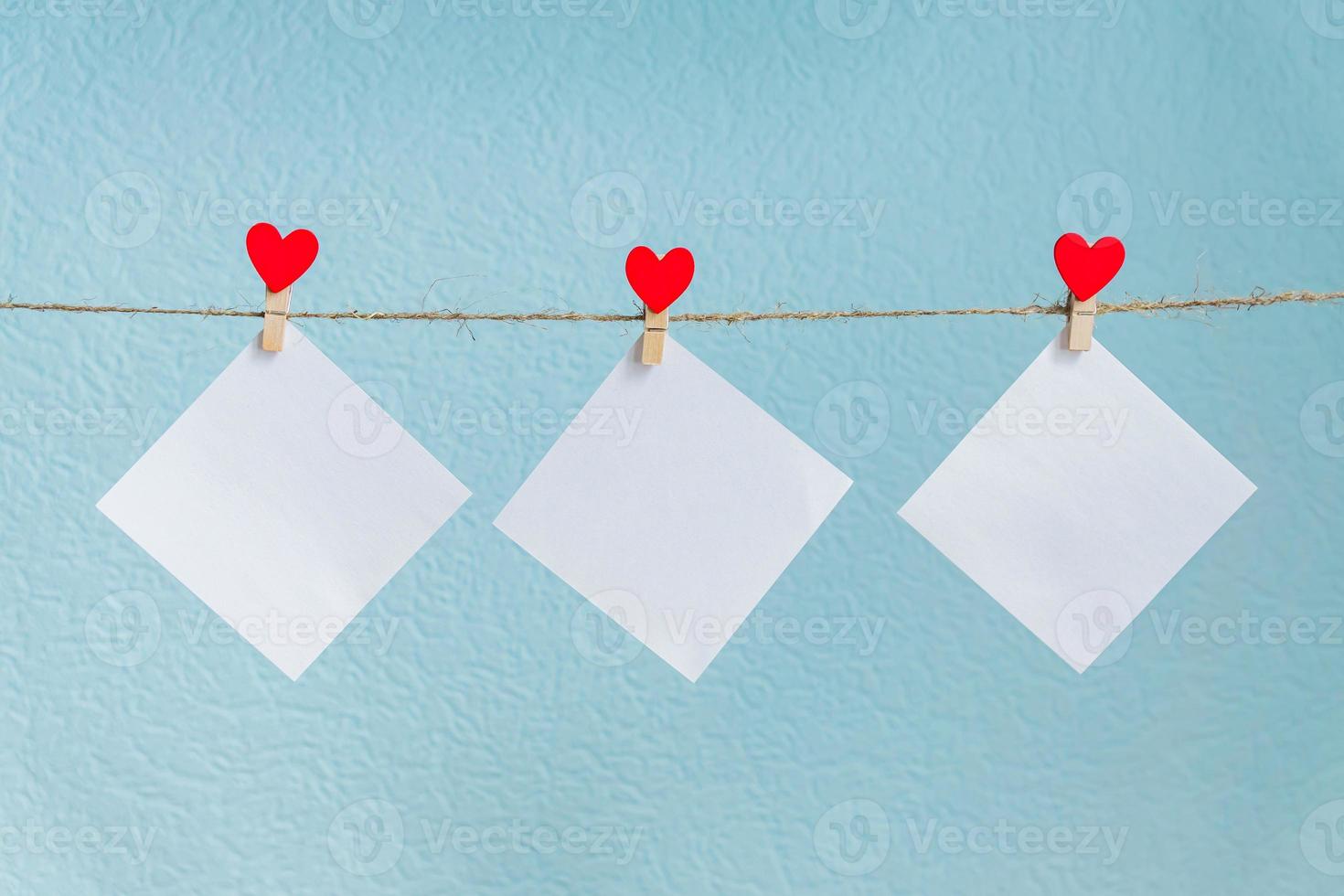 Blank cards on pins with red hearts. Mockup for text and blue background for Valentines Day greetings photo