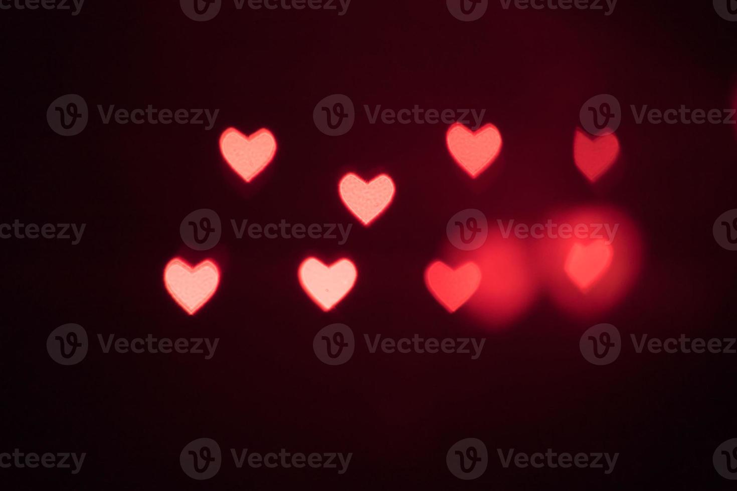 Pink hearts bokeh on black background. Festive Texture for holidays photo