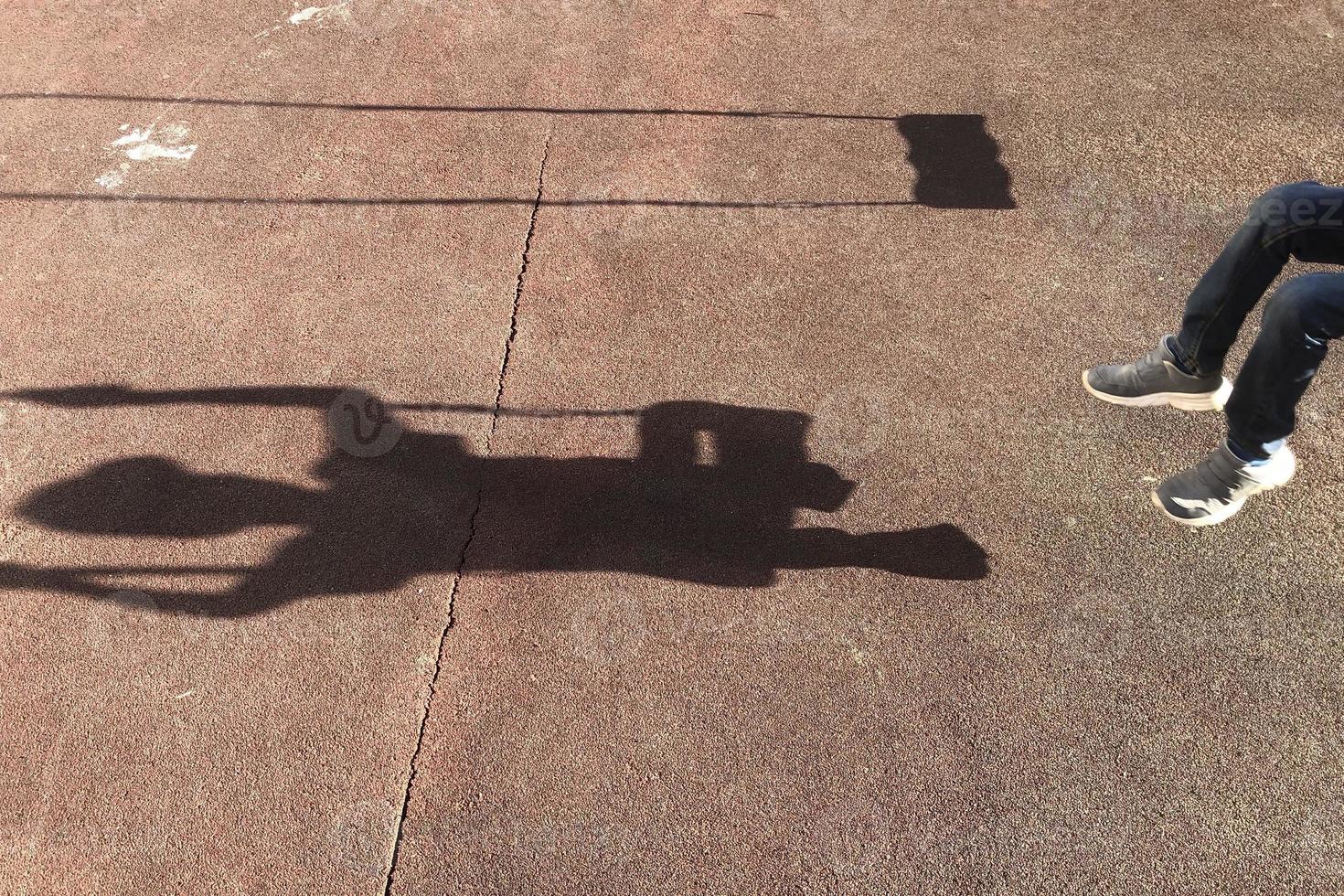 shadow of swinging boy on playground photo