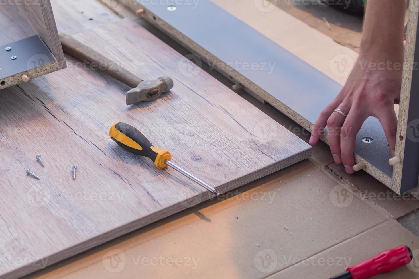 furniture assembling - Carpentry screws for a knock down wooden table. photo