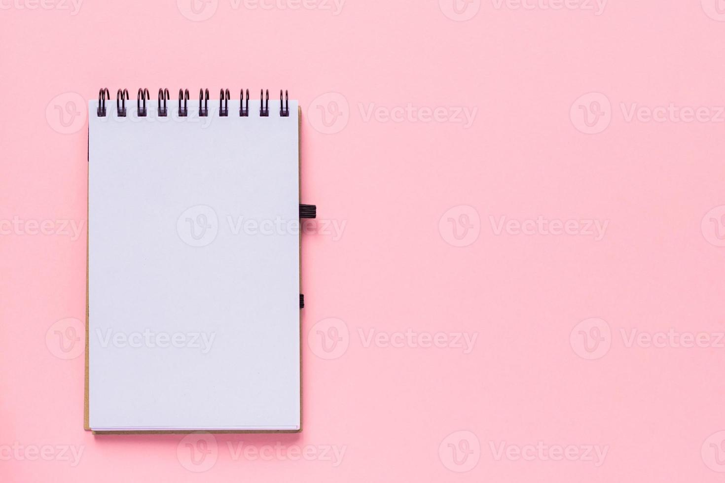Clean spiral note book for notes and messages on pastel pink background. Minimal business flat lay photo