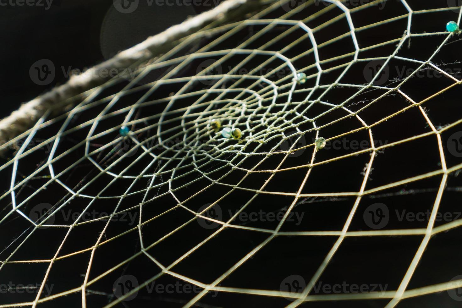 close up of a dream catcher with turquoise and yellow beads photo