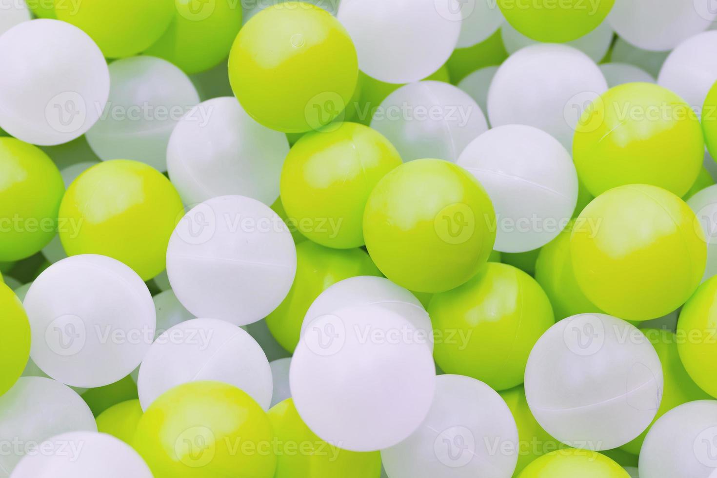 Close up of plastic white and yellow balls in dry pool on the playground photo