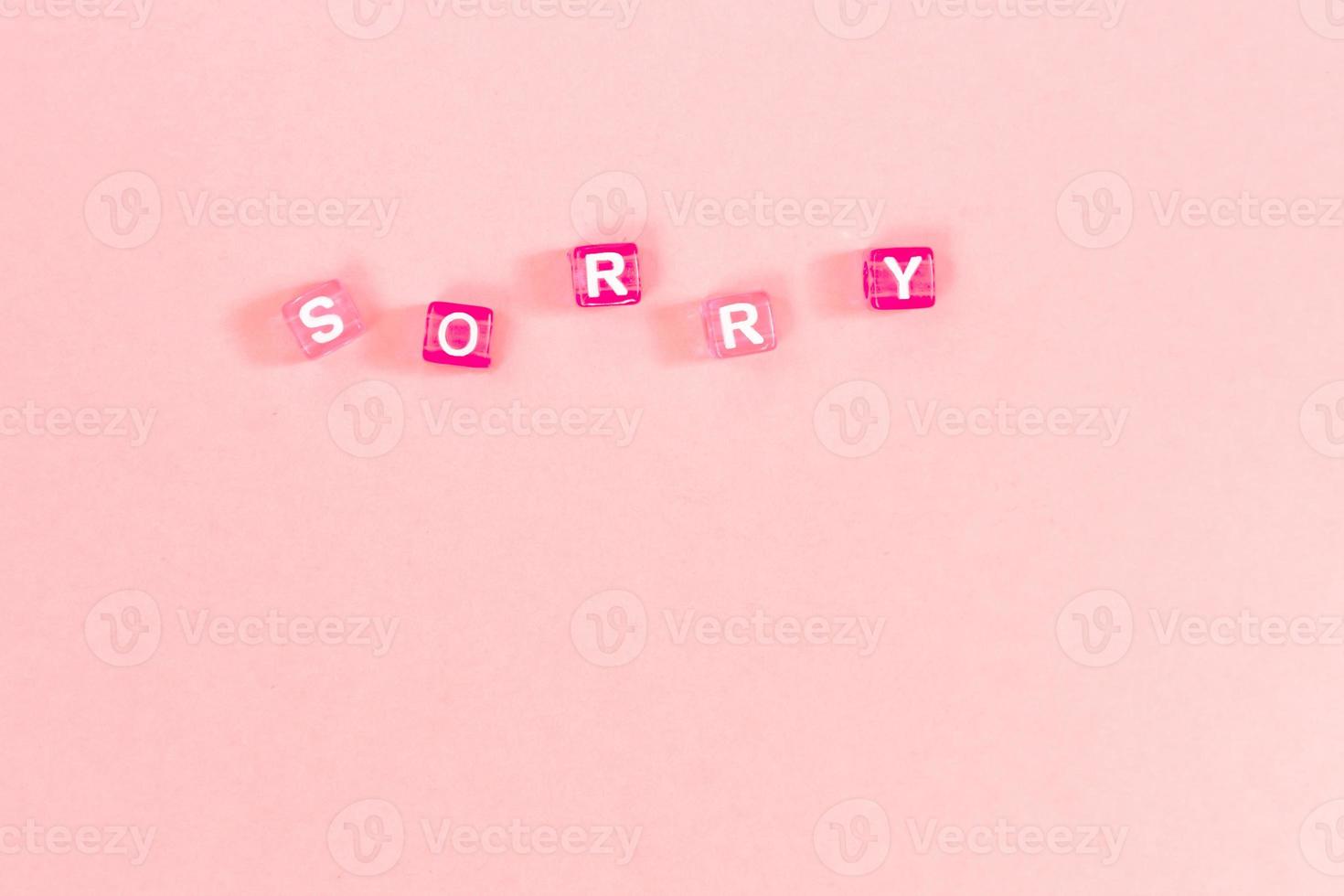 sorry  inscription made of colorful cube beads with letters. Festive pink background concept with copy space photo