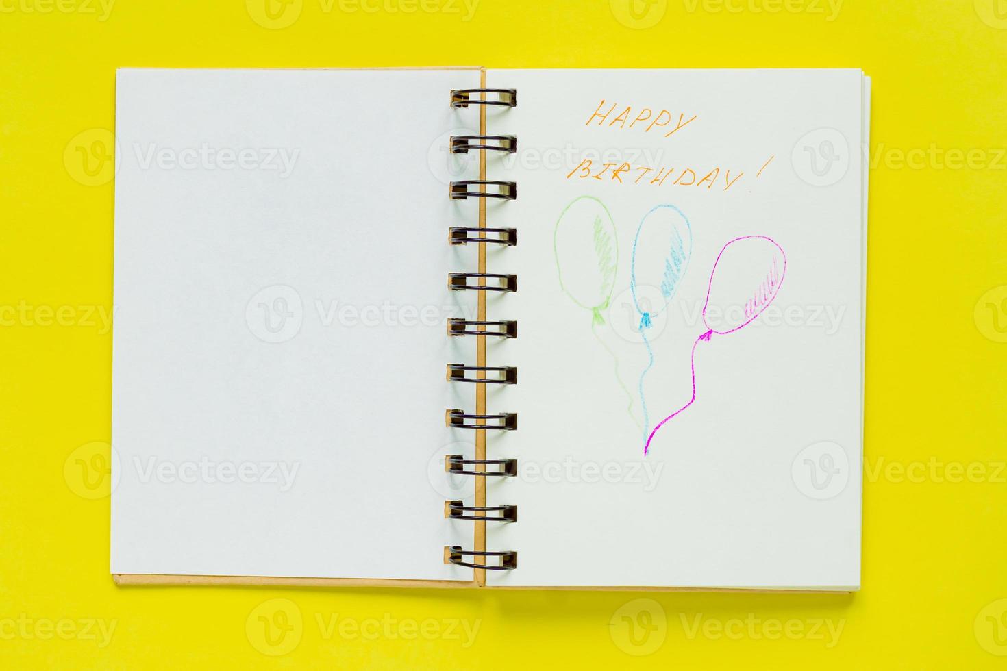 Top view of notebook with happy birthday greeting and three drawed balloons with copy space. Celebration consept photo