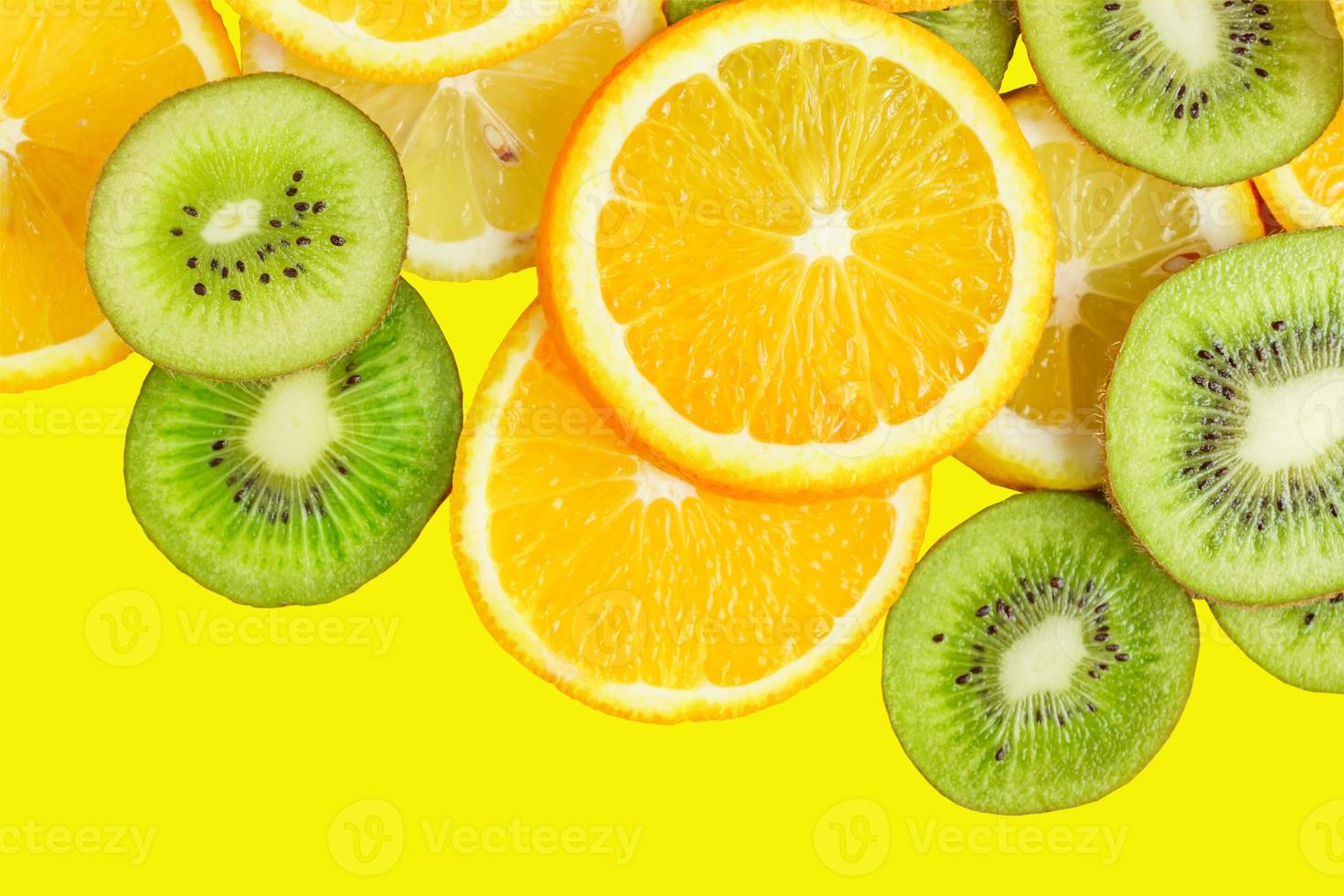 citrus slices - kiwi, oranges and lemons on yellow background. Fruits backdrop photo