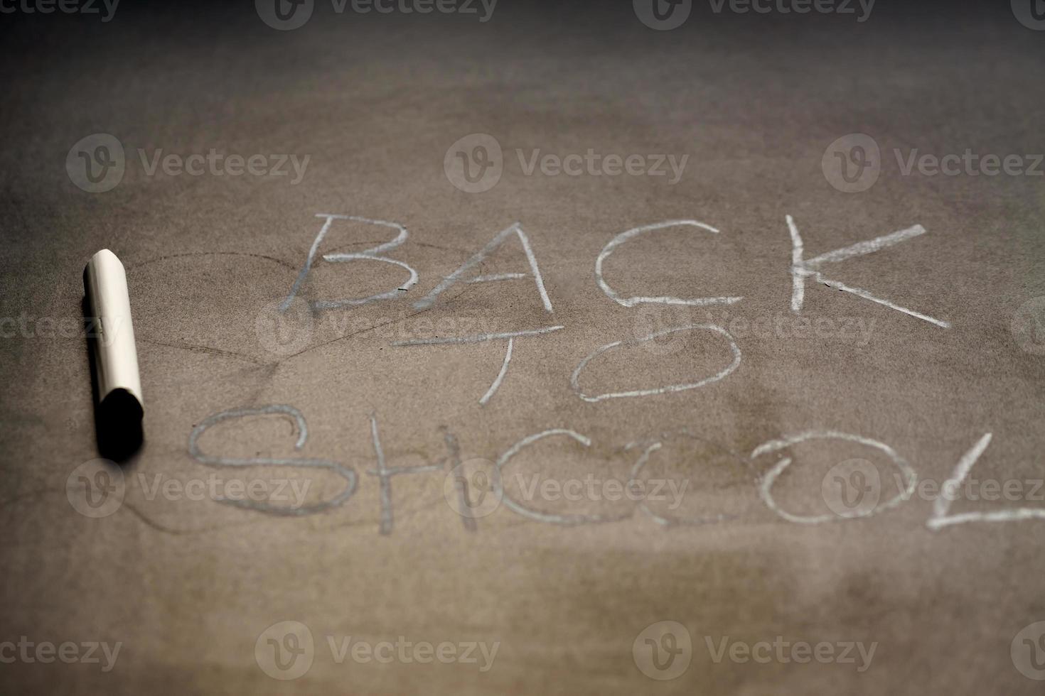 Back to school background.  White chalk text on school blackboard. Shallow depth of field photo