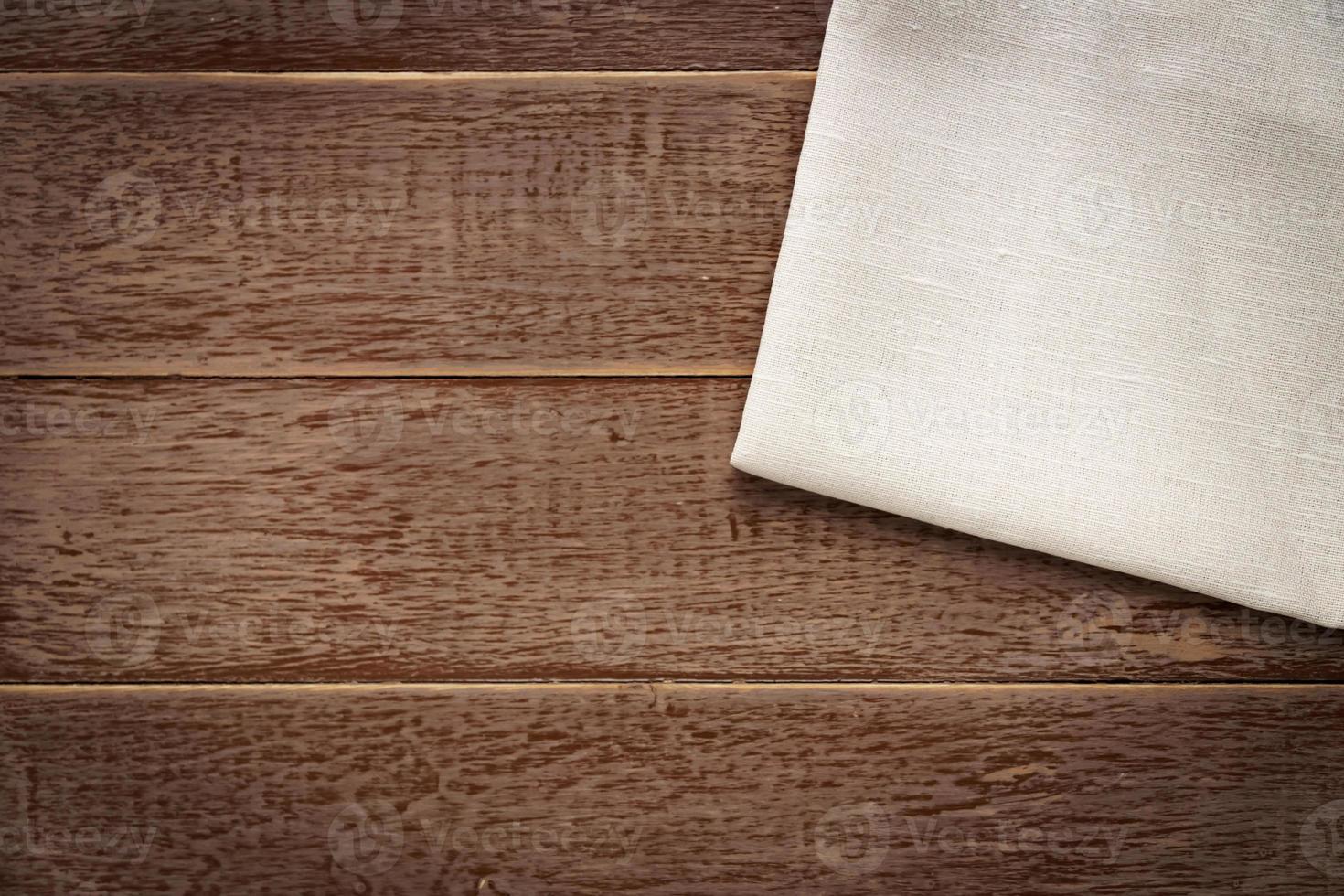 vista superior de la servilleta de tela de color beige con fondo rústico de madera. foto