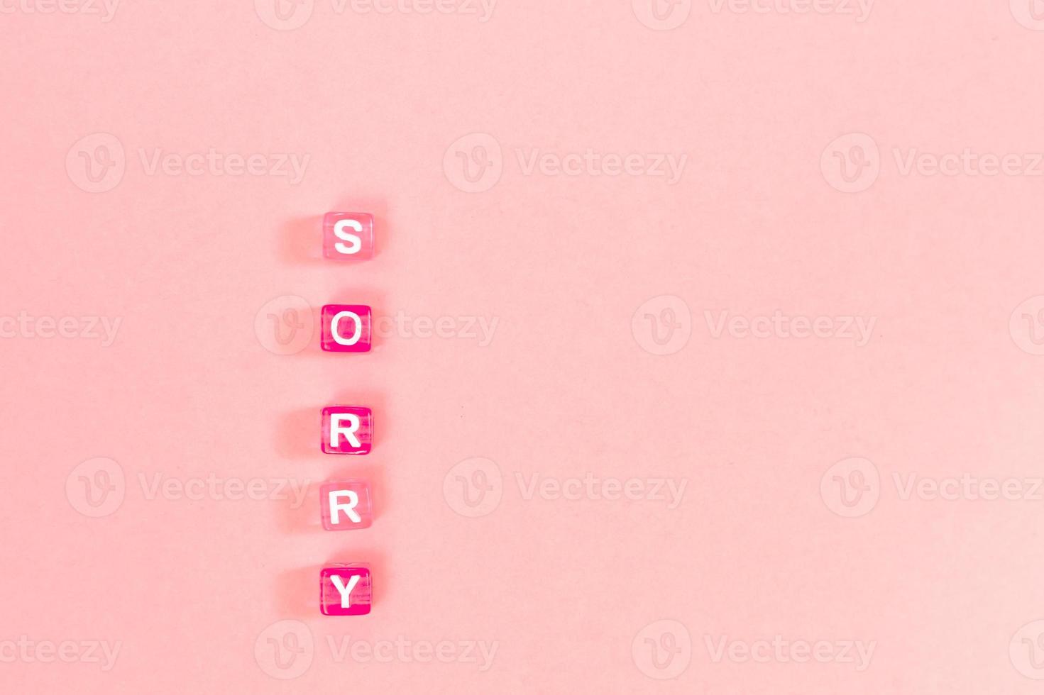 sorry  inscription made of colorful cube beads with letters. Festive pink background concept with copy space photo