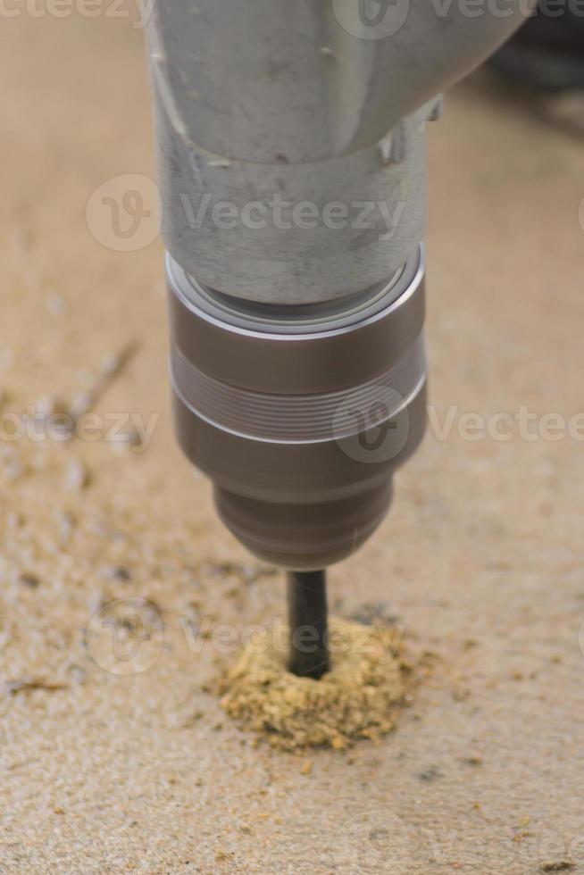 worker makes holes with a drill for secure fixing metal construction photo