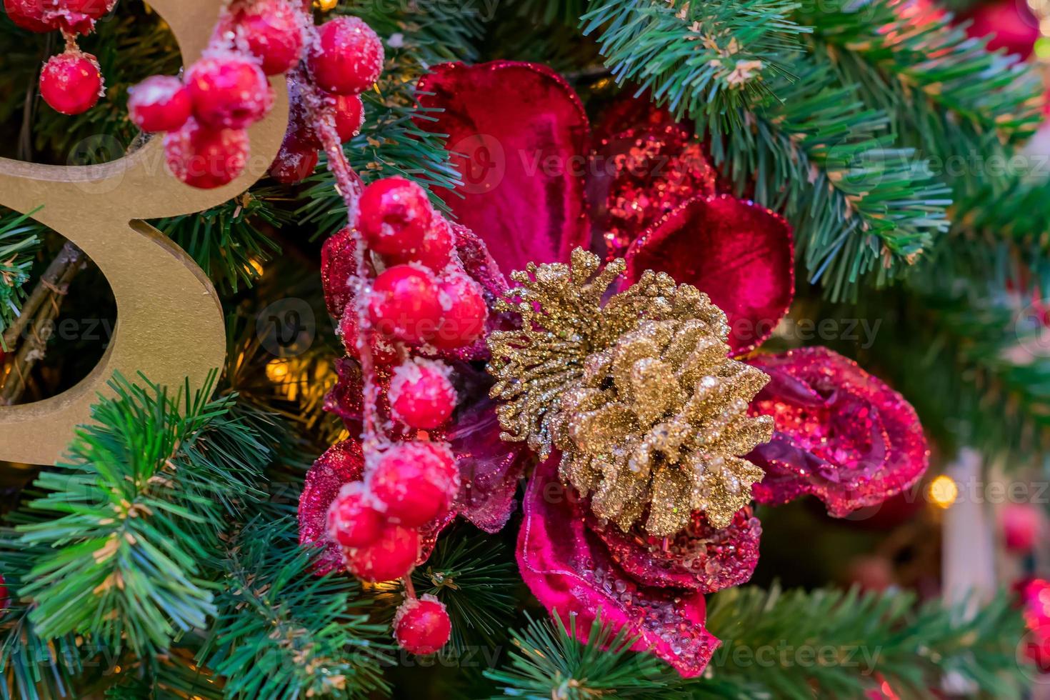 Christmas and New Year holidays background.  Christmas tree decorated with red frosted berries and balls.  Celebration concept photo