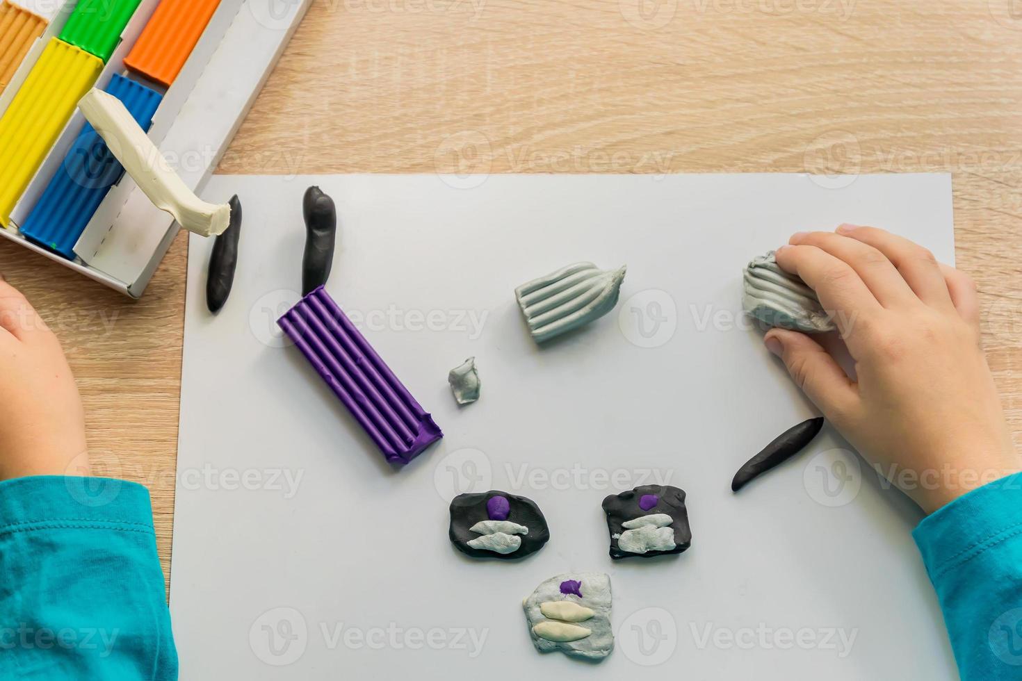 Hands of a little boy playing  with colorful modeling clay. Creative kid molding at home. photo