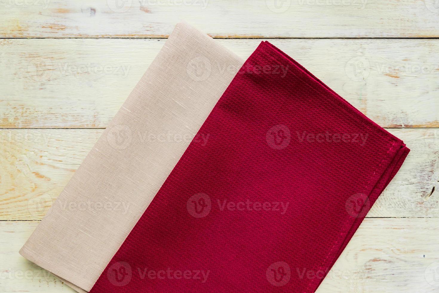 Top view of cloth napkins of beige and burgundy colors in rustic white background. photo