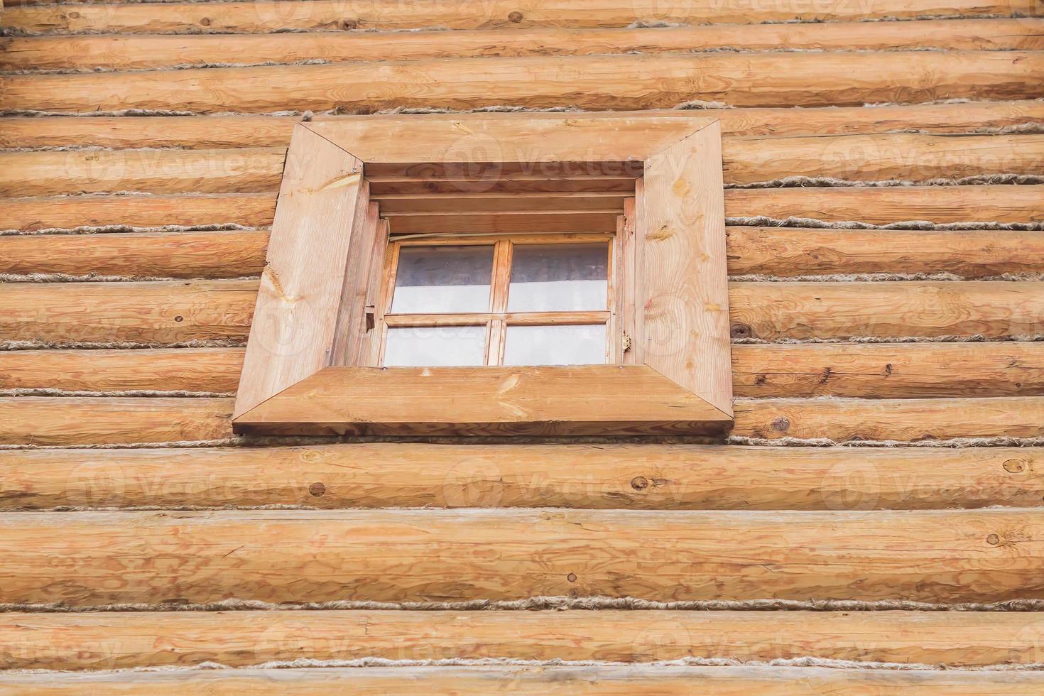 wooden log wall with window, background. photo