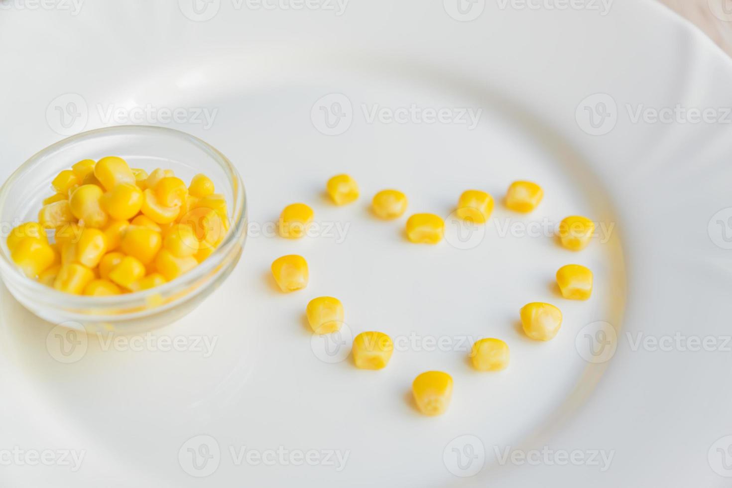 Close up of sweet corn in shape of heart  on white plate. photo