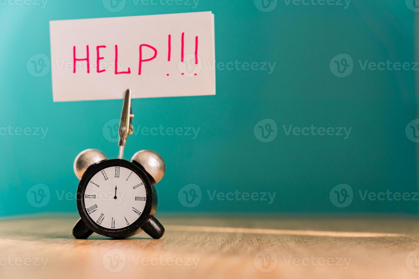 Alarm clock and banner with handwritten phrase help on wooden table. Time management concept. photo