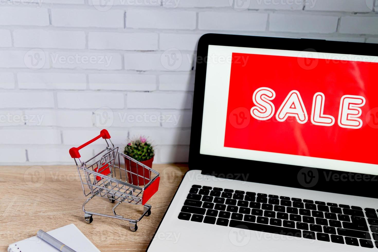 Small red shopping cart or trolley near laptop, Technology business online shopping concept photo