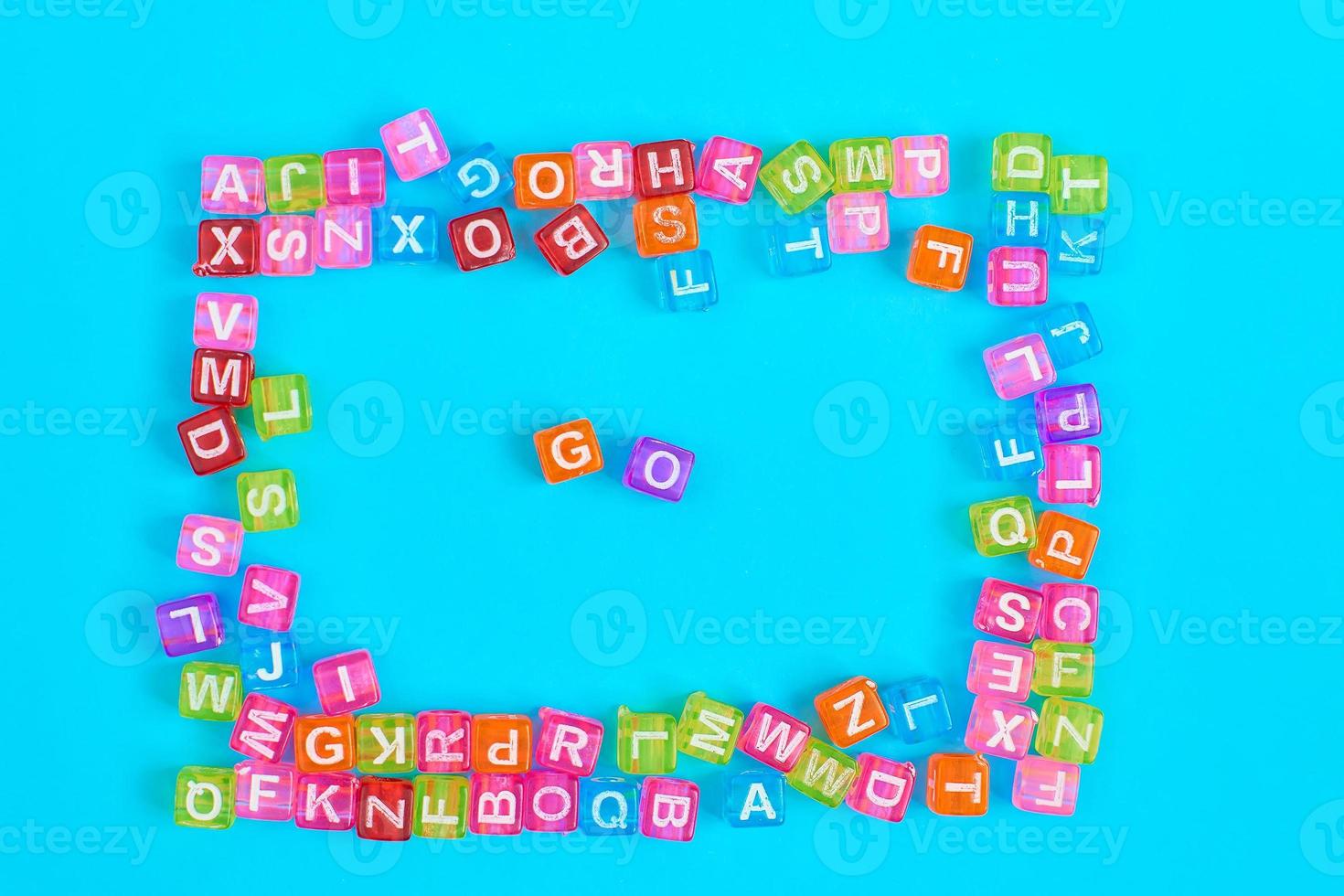 GO inscription made of colorful cube beads with letters. Festive blue background concept with copy space photo