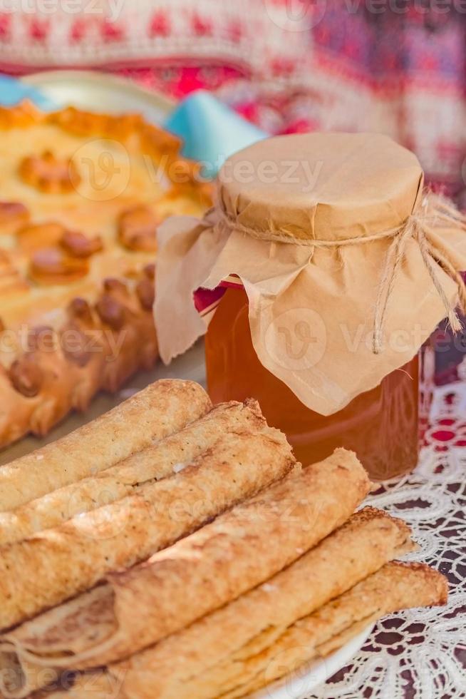 Tasty rolled pancakes and jar of honey, close up. photo