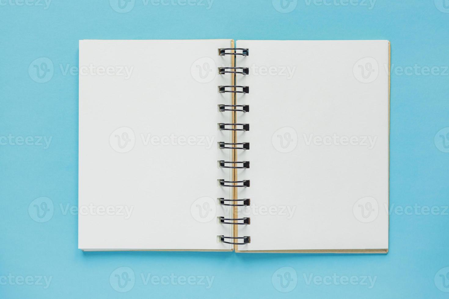 Top view of open empty notebook with cover from recycled paper on pastel blue colorful background photo