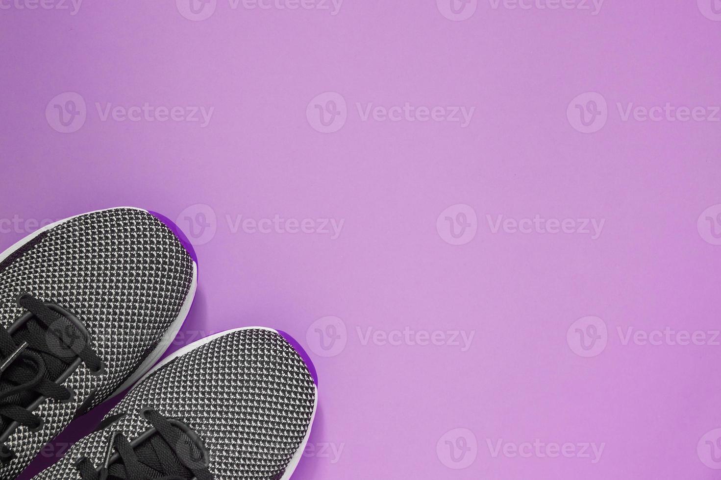 Sport Shoe on purple background. Black and white female sneakers for training. Lifestyle concept with copy space. Top view photo