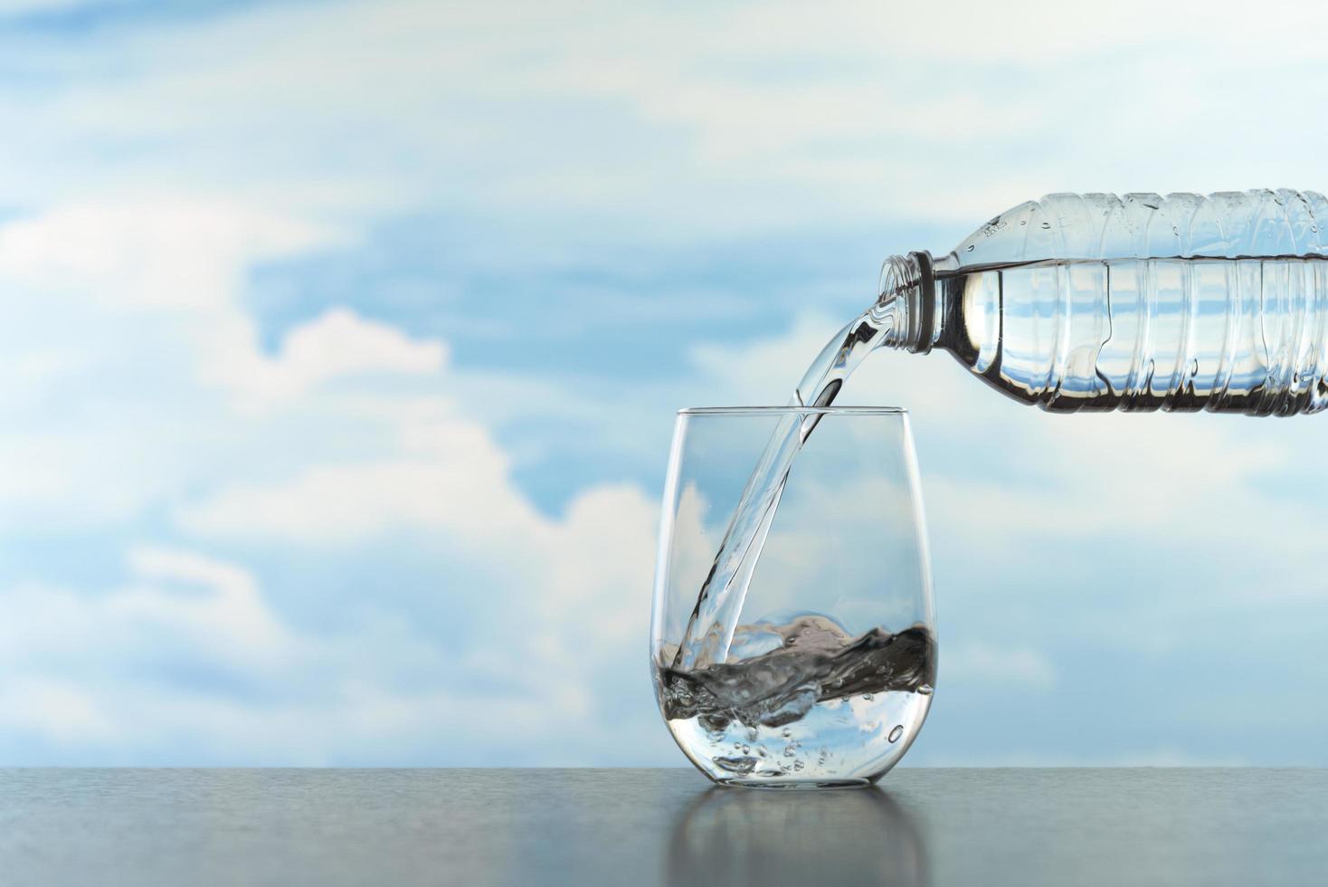 salpicaduras de agua en un vaso transparente después de verter agua foto