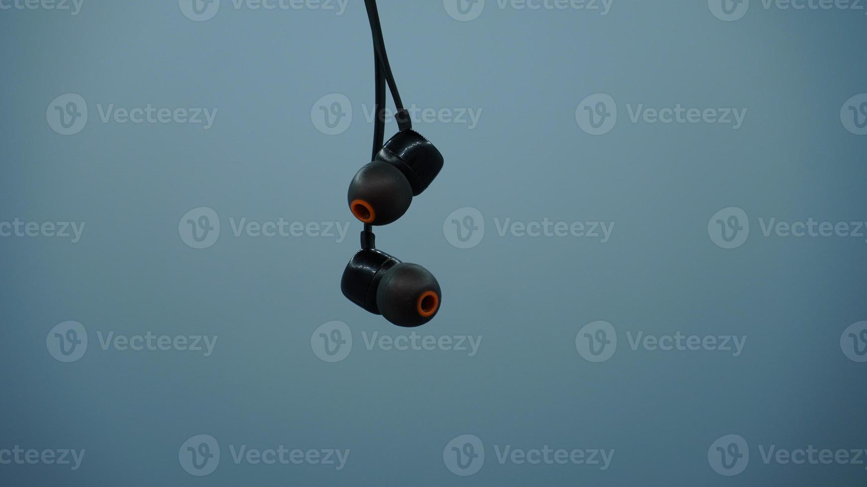 Black earplug on white background music concept photo