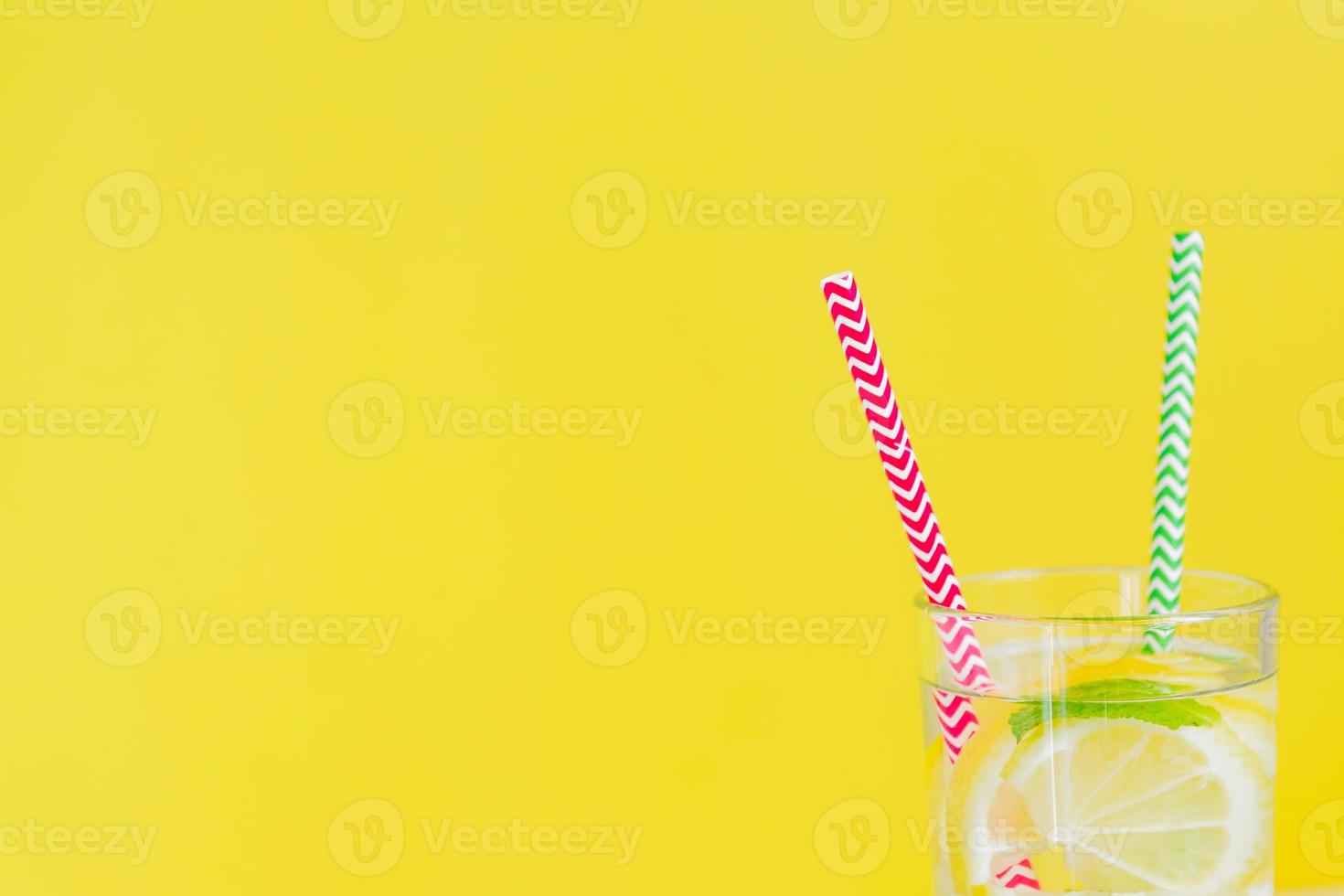 Homemade lemonade with lemon and mint on colored yellow background. Summer cold drink cocktail. Copyspace photo