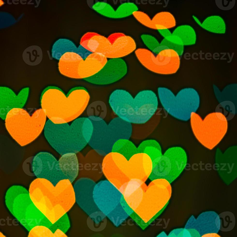 Bokeh de corazones multicolores sobre fondo negro foto