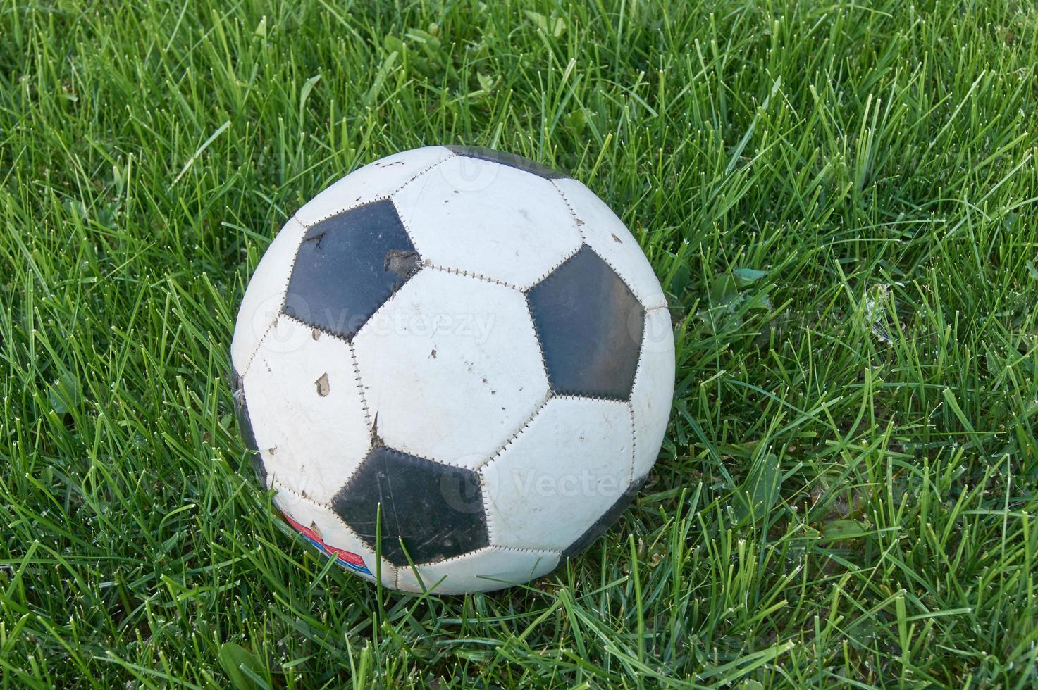 Used Football ball on green grass. top view with copy space. Sports and recreation concept photo