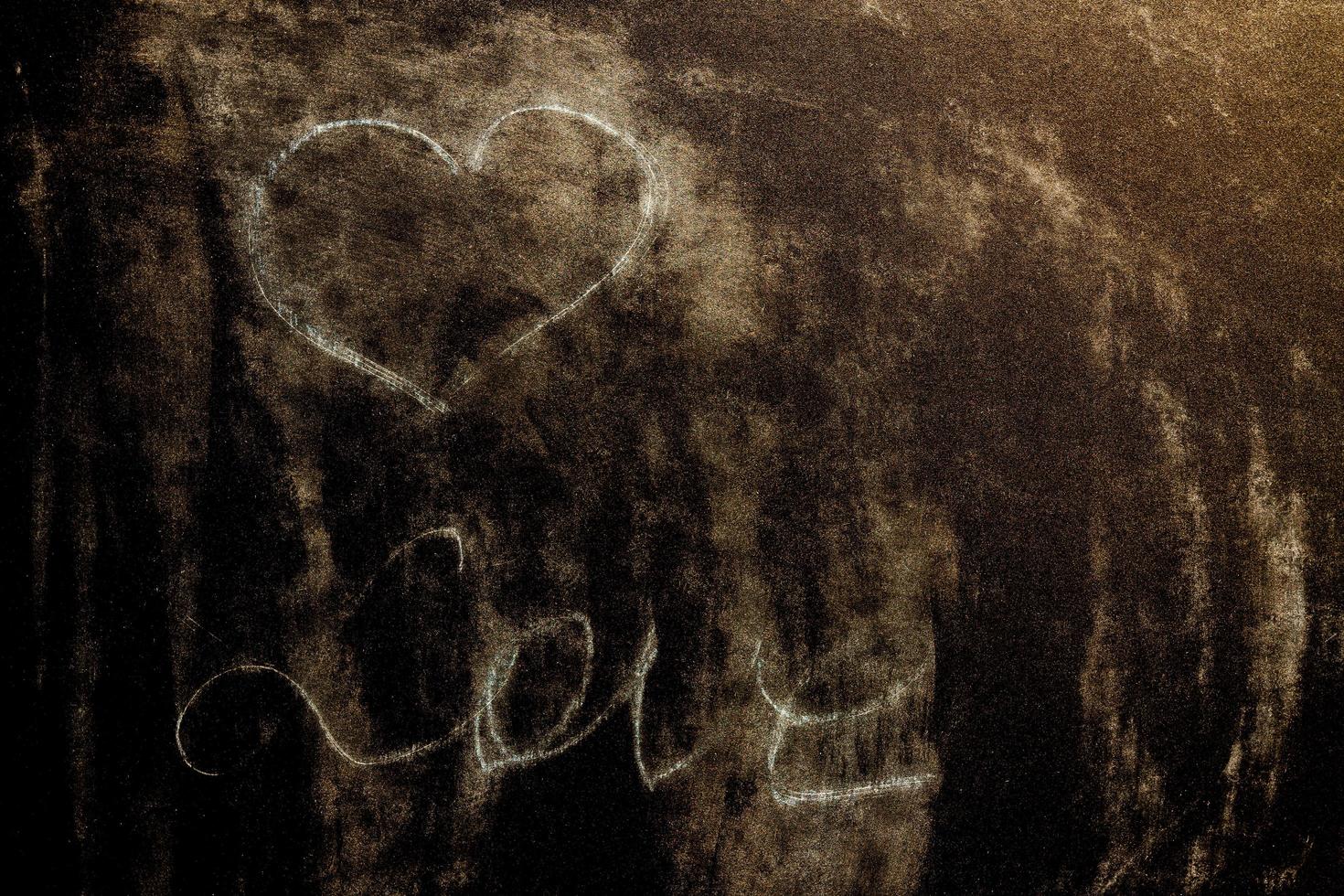 A chalk board with the word love and a heart. Grunge background texture photo