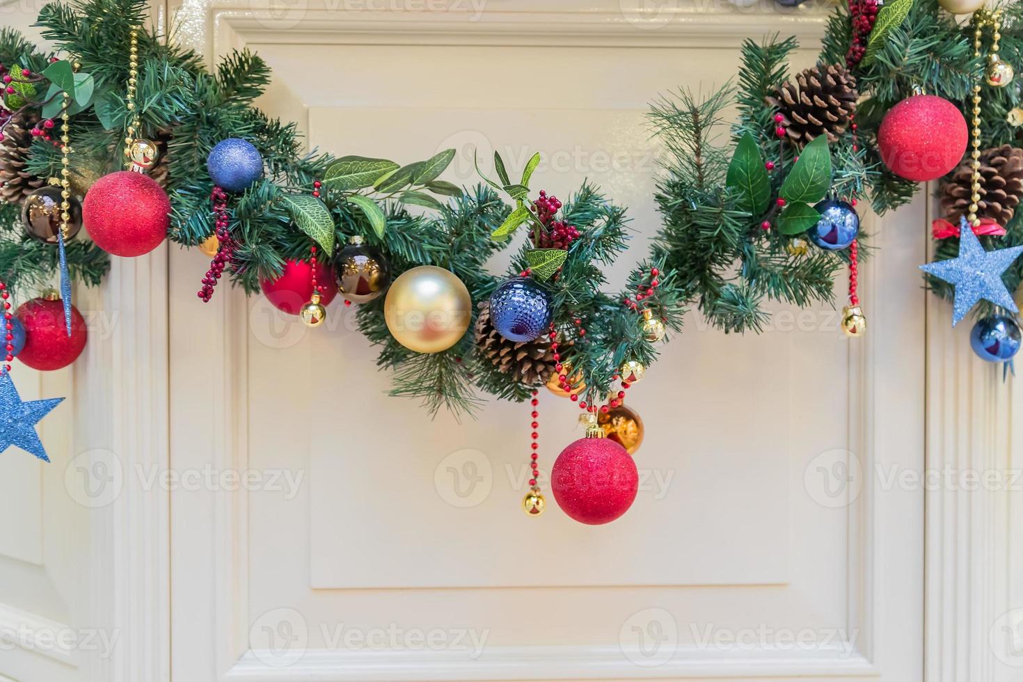 Beautiful christmas garland decorated with fur tree branches. multicolored baubles and cones. Interior holiday decoration photo