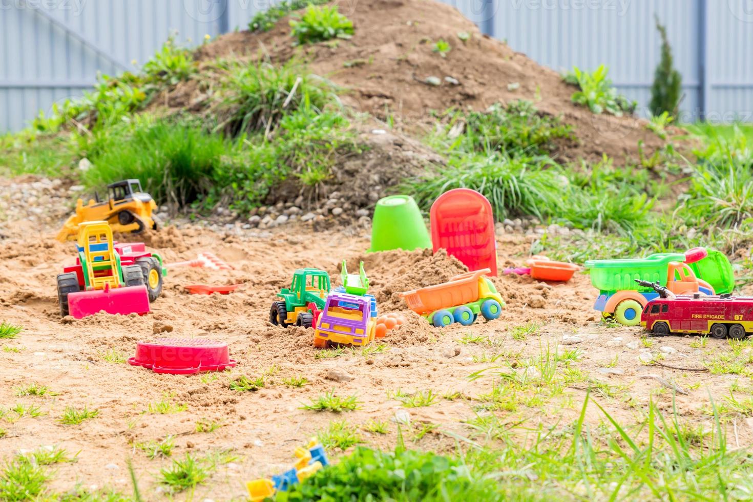 parque infantil con diferentes transportes de juguetes. camiones y excavadoras para jugar en la arena foto