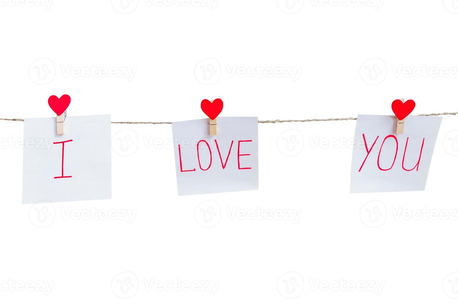 Red Valentine's love hearts pins hanging on natural cord isolated on white background. I love you inscription on paper pieces. photo