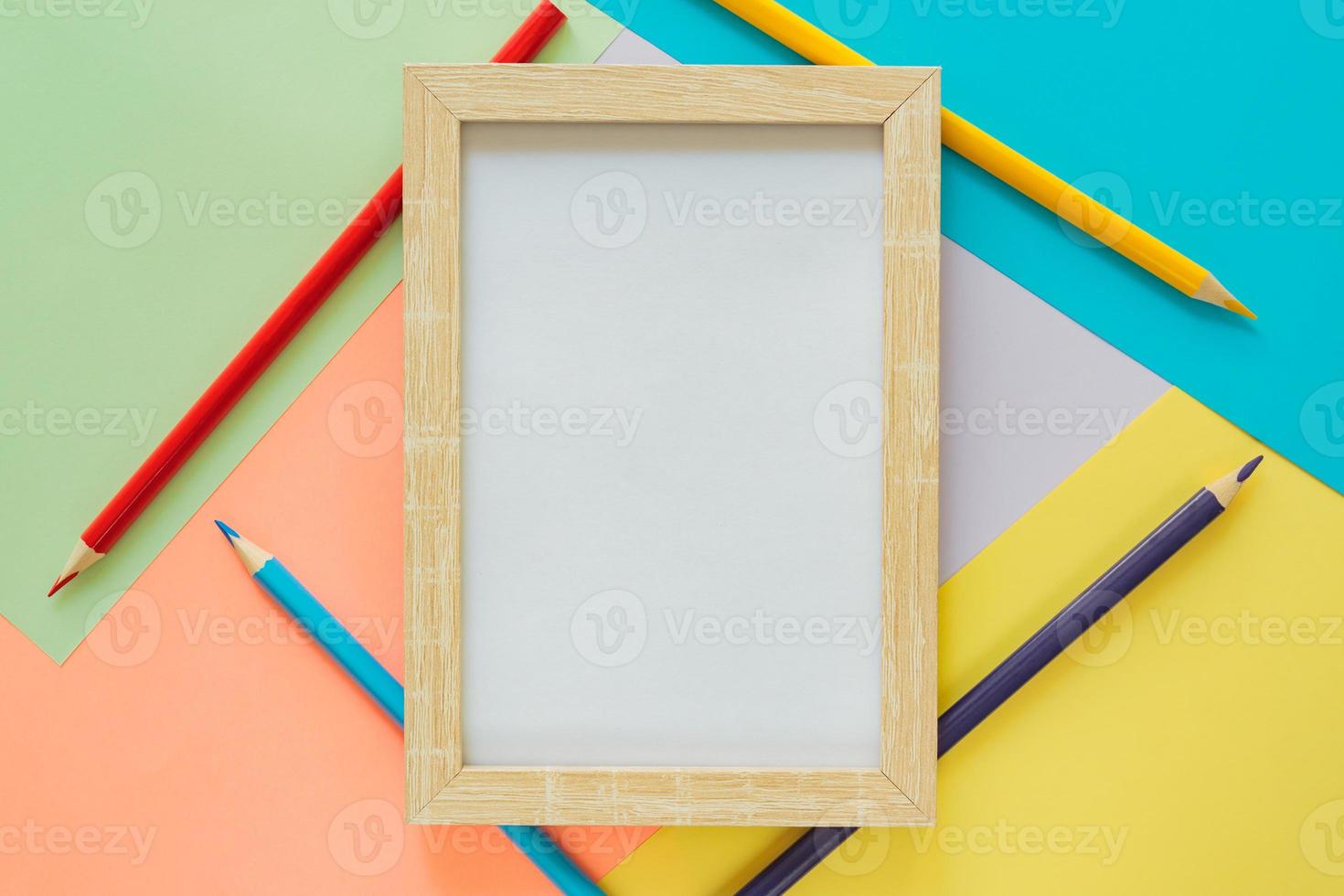 Creative flat lay with school suppllies. Mock up frame and multicolored pencils on pastel colorful background. Back to school. photo