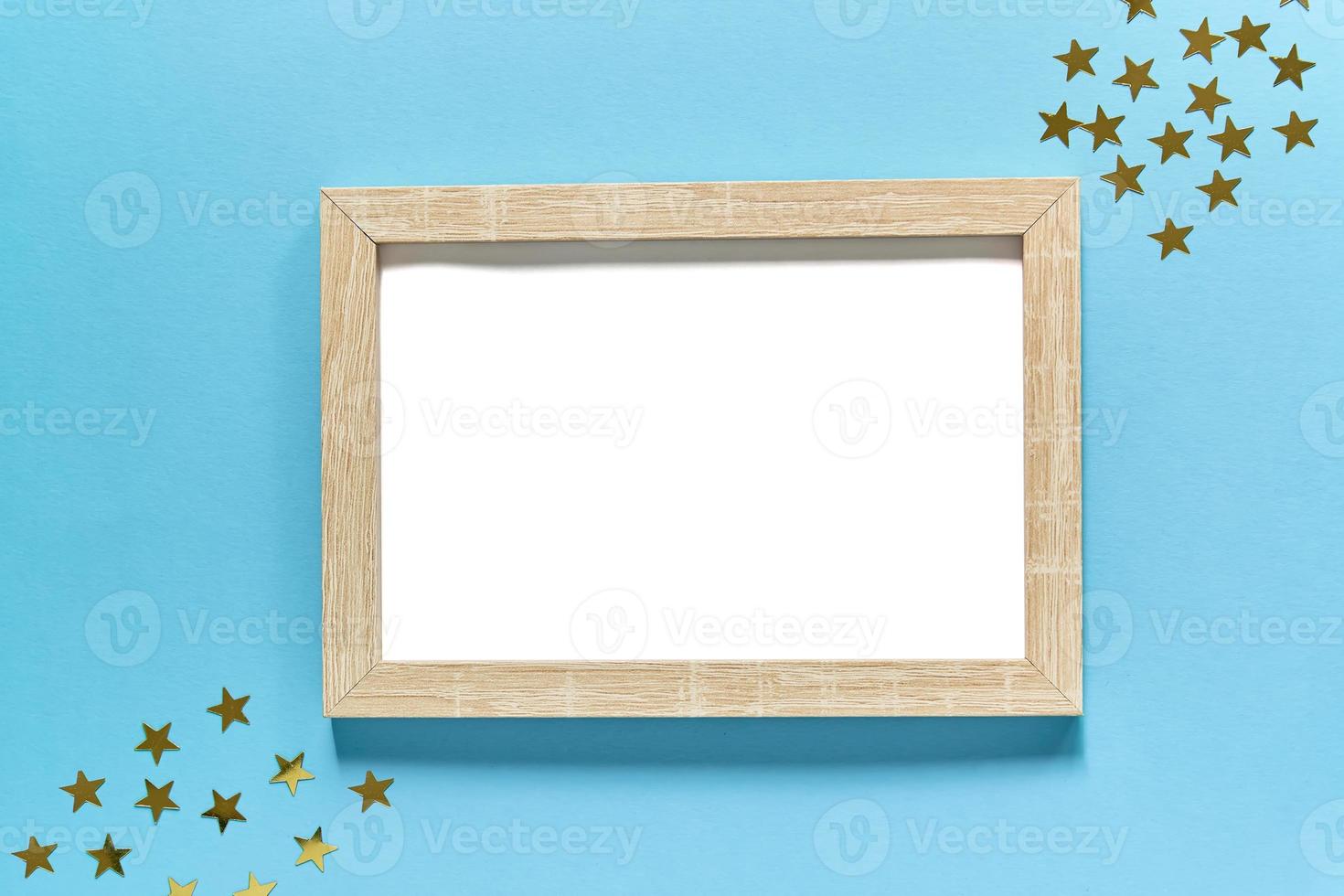 picture frame mockup on blue background with golden stars confetti. Space for your design photo