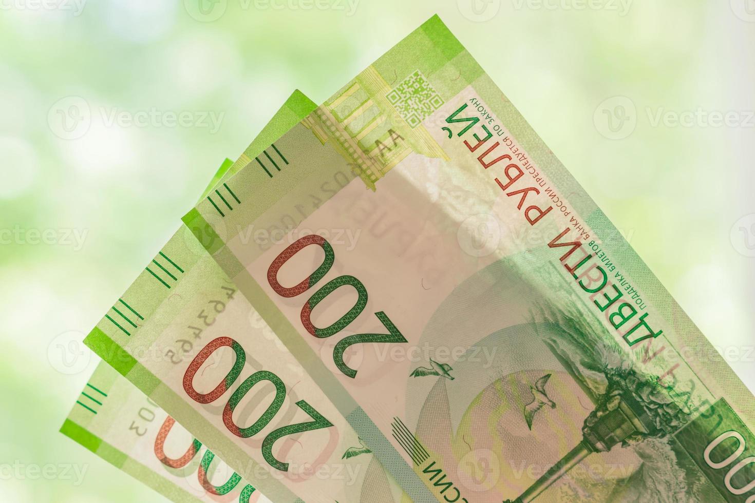new russian banknotes against green bokeh background. two hundred roubles. Cash paper money. photo