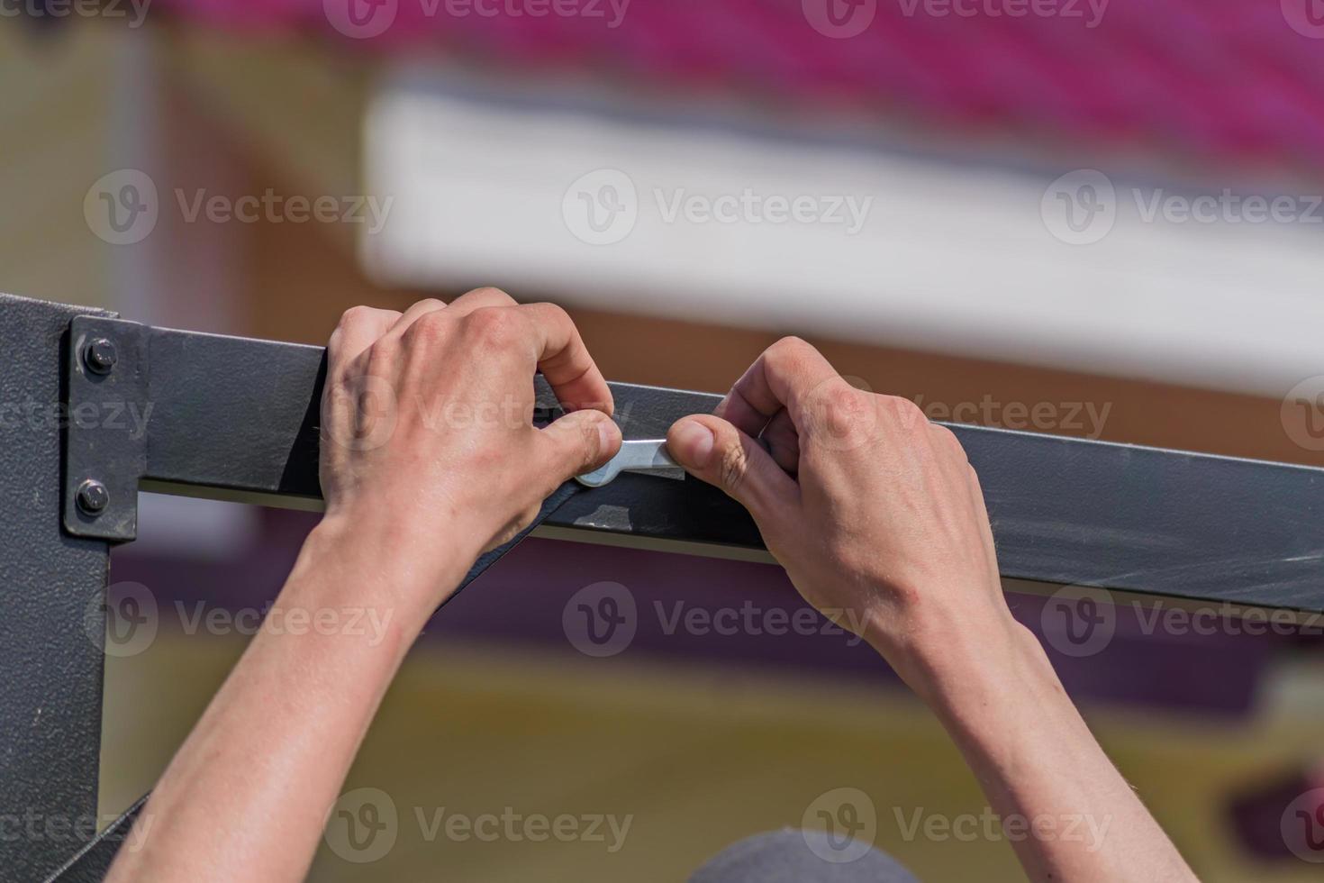 trabajador con una herramienta de mano que ensambla la construcción de metal al aire libre foto