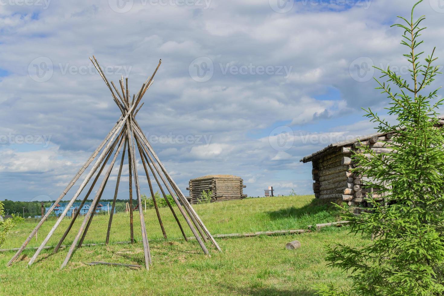 wooden construction on the meadow under cloudy sky. Landscape photo