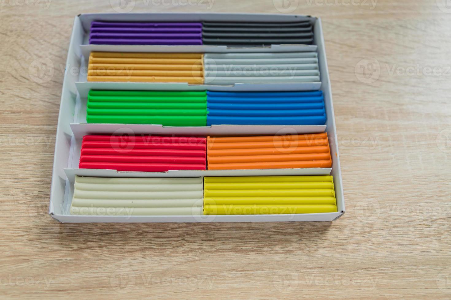 Set of multicolored plasticine bars for modeling on wooden table. Top view, eduction and creativity concept photo