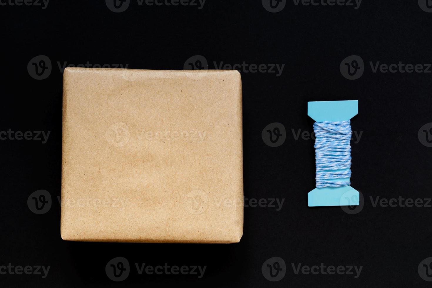 Handcrafted gift box wrapped in Craft paper with blue ribbon and bow photo