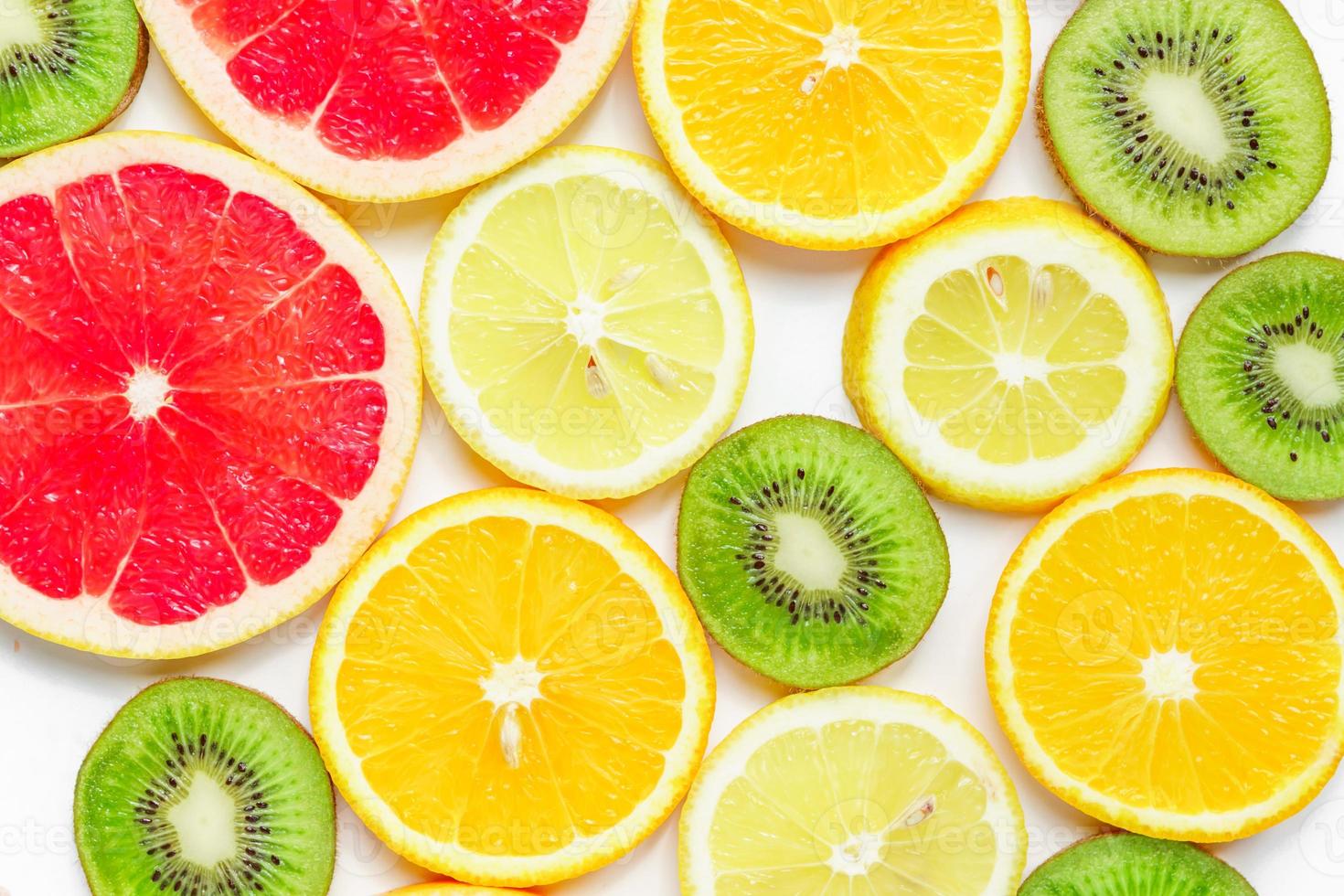 citrus slices - kiwi, oranges and grapefruits on white background. Fruits backdrop photo