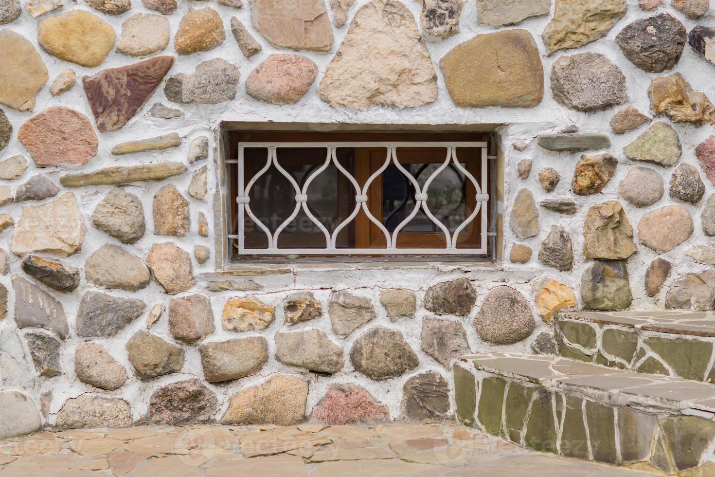 old stone wall and white lattice on a window. photo