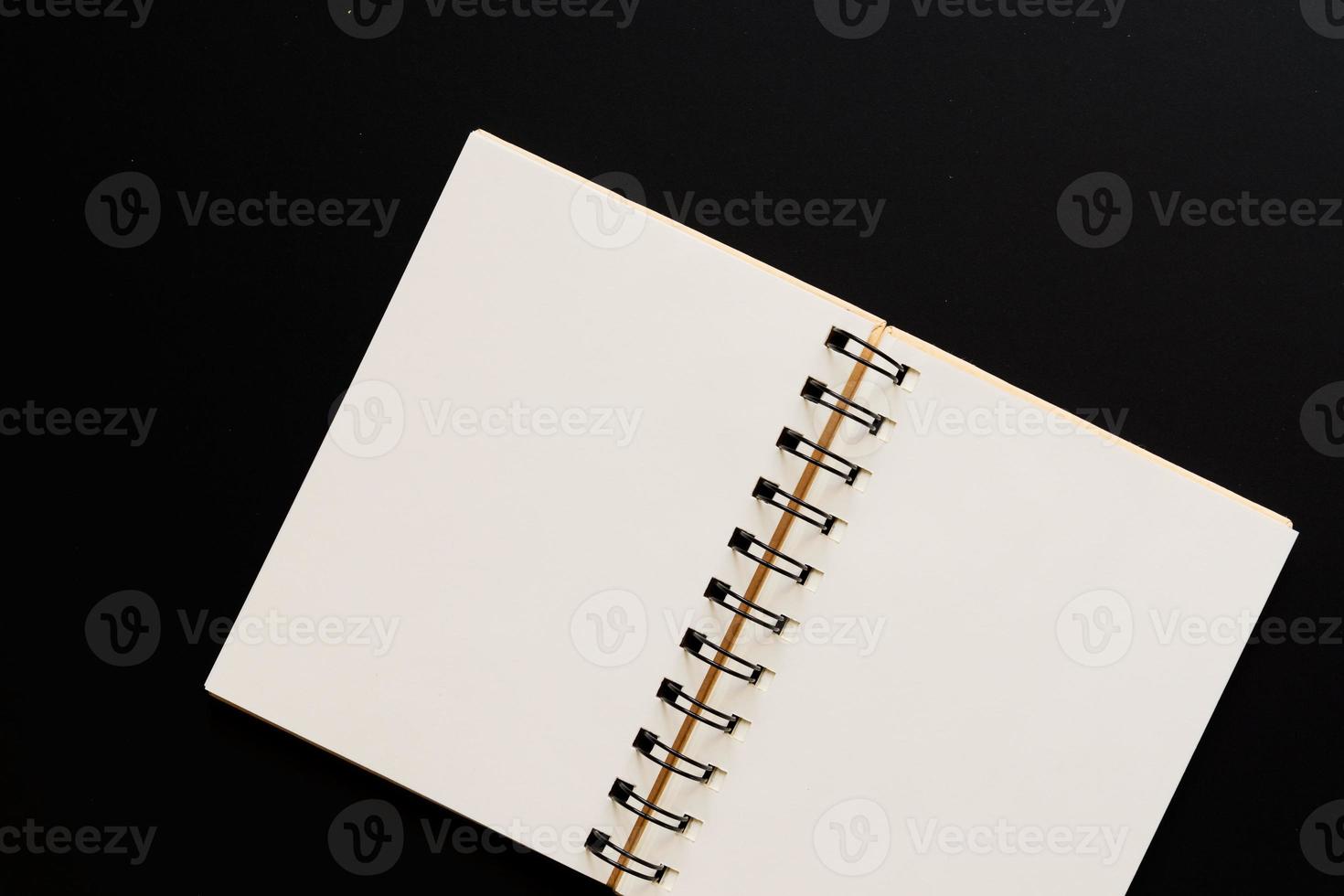 concepto de diseño: vista superior del cuaderno kraft vacío sobre fondo negro. Bosquejo. foto