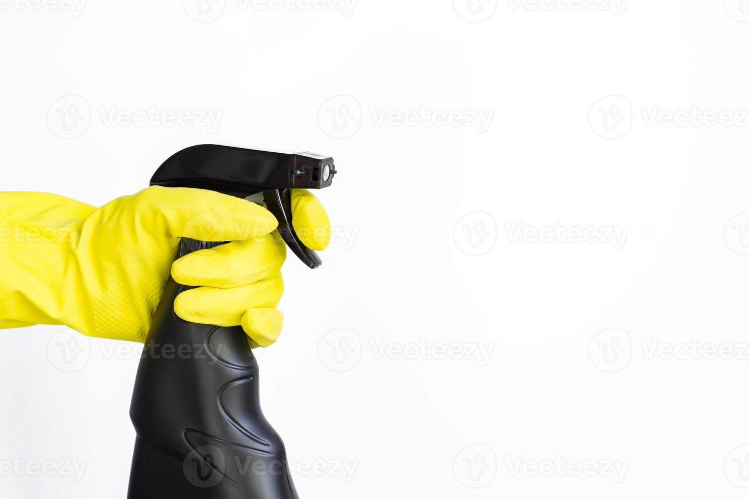 hand in pink rubber glove holding black plastic spray detergent bottle. Household chemicals. Cleaning product. photo